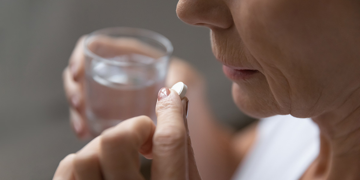 elderly patient with medication and a glass of water