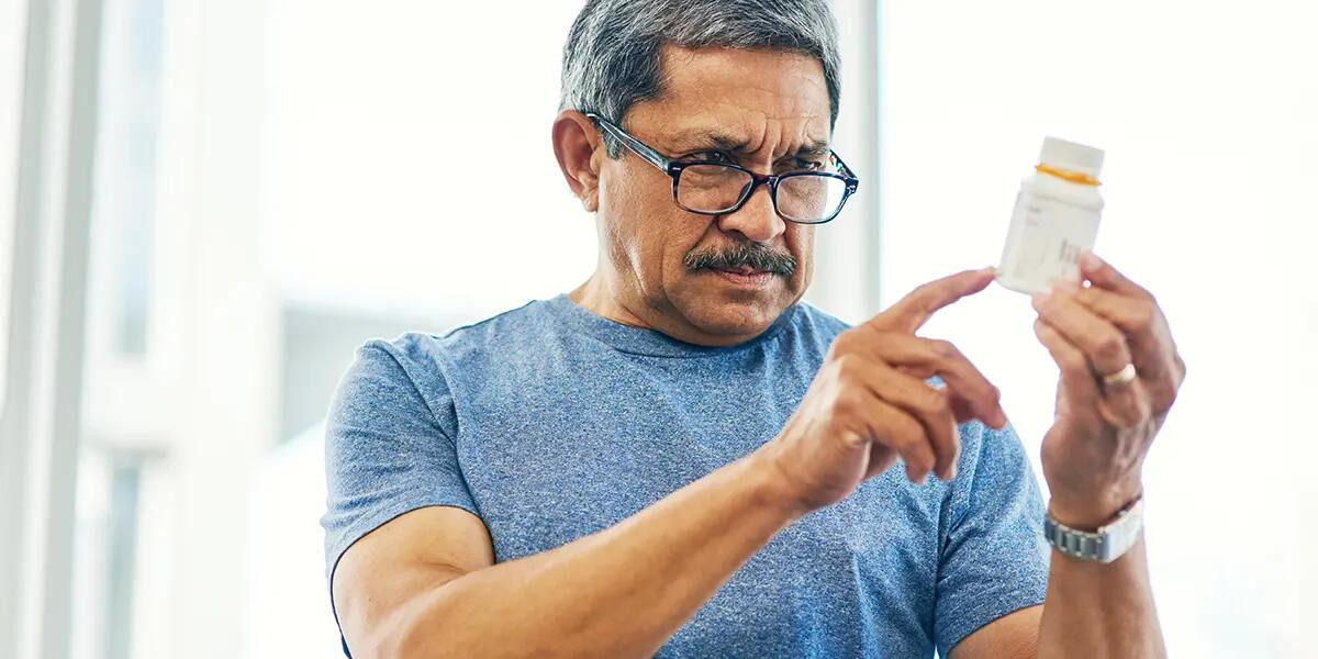 older gentleman reading medication bottle