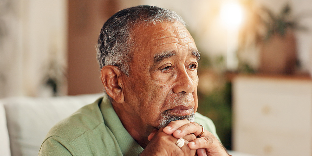 older adult man resting chin on hands