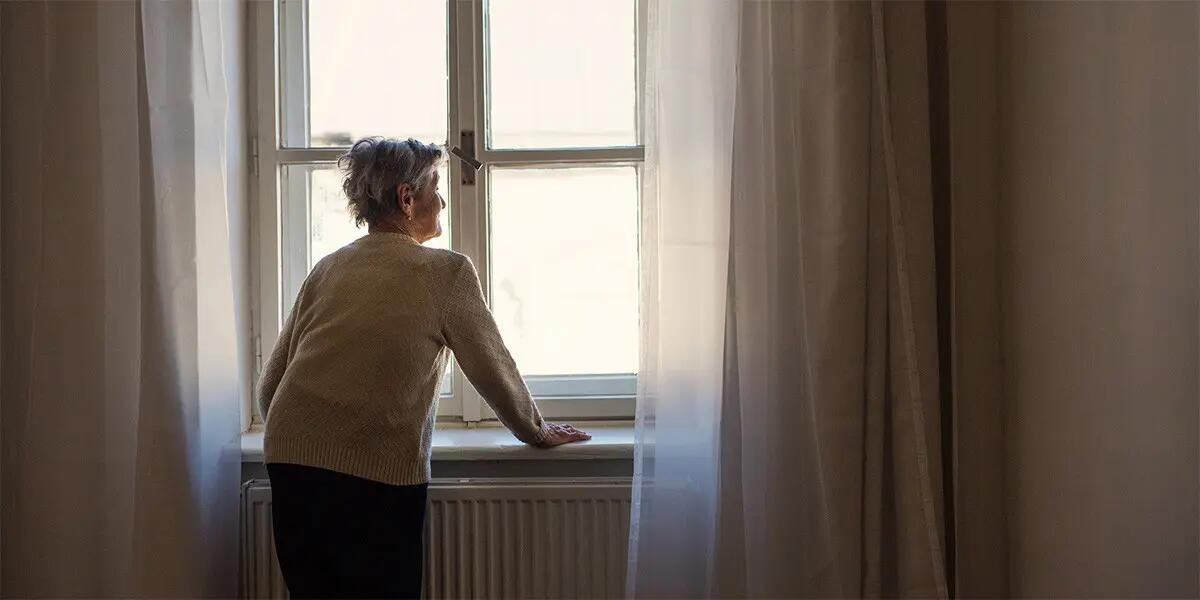 Elderly woman looking out the window