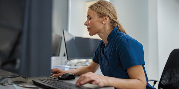 Healthcare worker seated at desk in front of computer