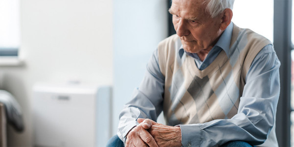 Elderly man sitting looking concerned