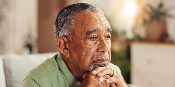 older adult man resting chin on hands