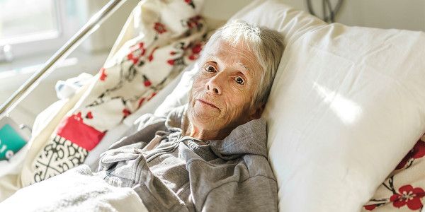 elderly frail woman in hospital bed