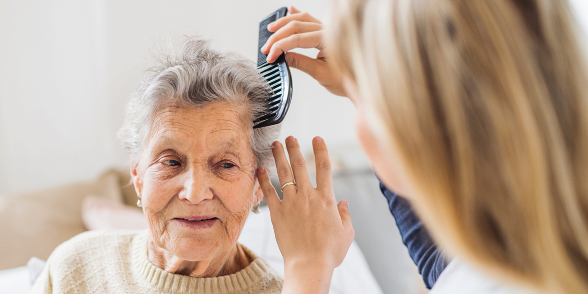 caregiver combing elderly woman's hair