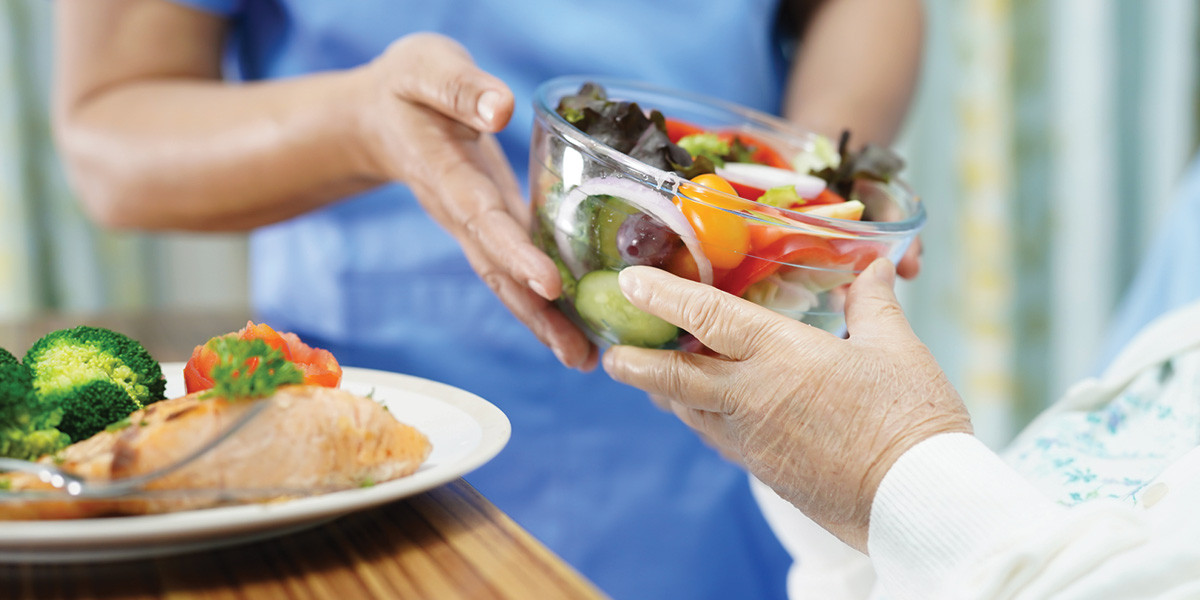 healthy foods being served to elderly person in healthcare facility