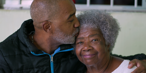 minority elderly couple in caring embrace