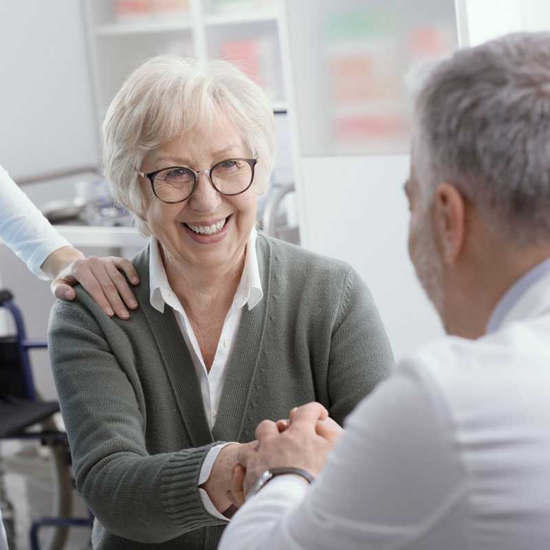 Smiling woman holding hands with a Doctor