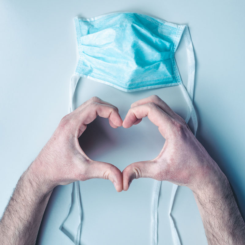 A doctor making a heart with his hands