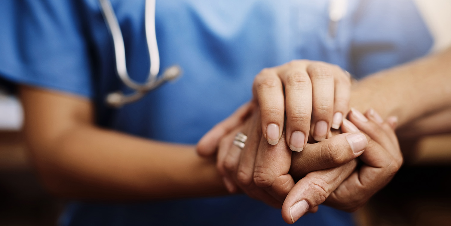 An older man sits with a nurse